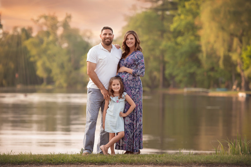 Family of 3 standing by a lake photo taken by Detroit Family Photographer Kat Figlak