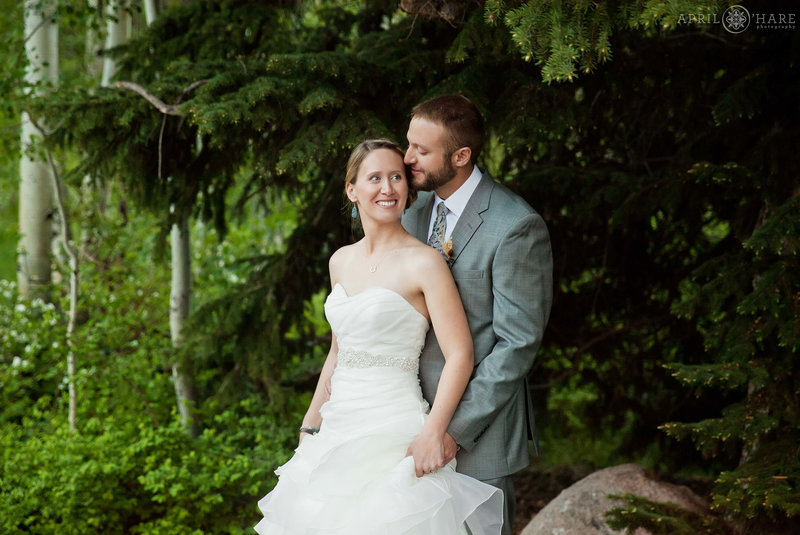 Portrait of a wedding couple outside in the greenery next to Donovan Pavilion in Vail Colorado