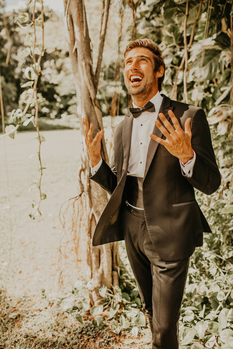 A  Groom celebrating with his hands in the air.