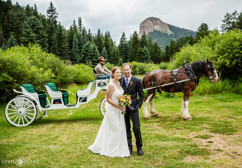 Couple pose with the horse drawn carriage at Mountain View Ranch in Colorado