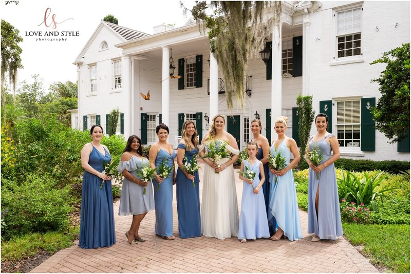 A  beautiful bride with 7 bridesmaids and a flower girl in various shades of blue at Selby gardens in Sarasota