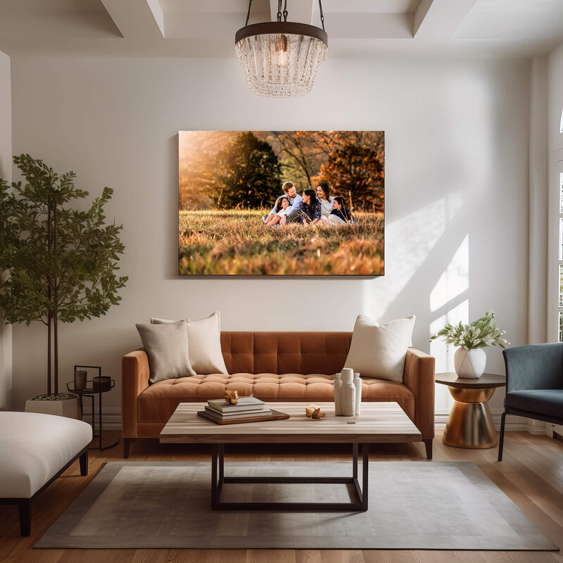 A modern living room featuring a large canvas print of a family sitting in the grass and laughing