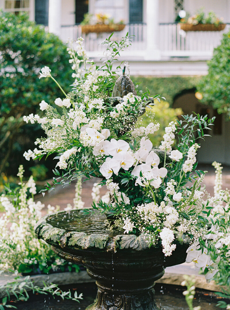 The fountain at Thomas Bennett House decorated in white flowers for a fall wedding ceremony.
