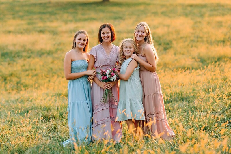 Mother and daughters in a field wearing pastel colors