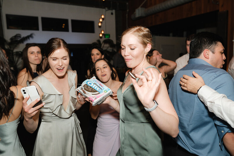 Bridesmaid holds a pack of Oreos on the dance floor