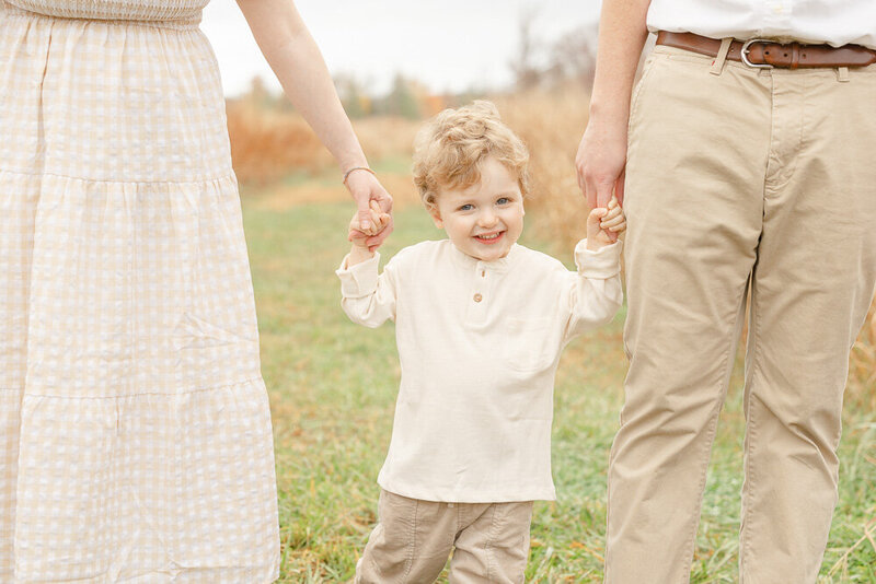Son holding parents hands during Manassas, Virginia session