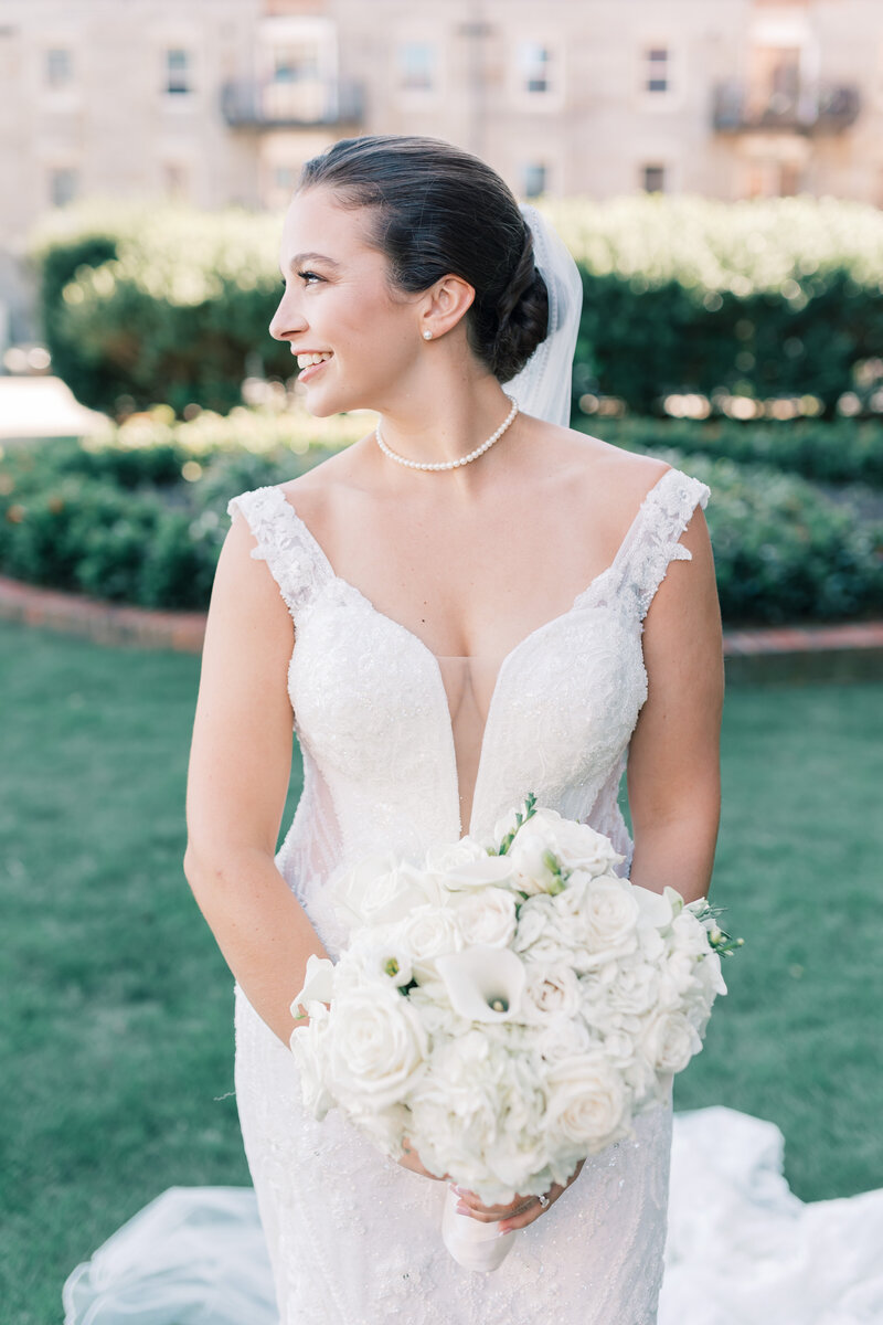 Stunning bride holds bouquet and smiles looking to her right