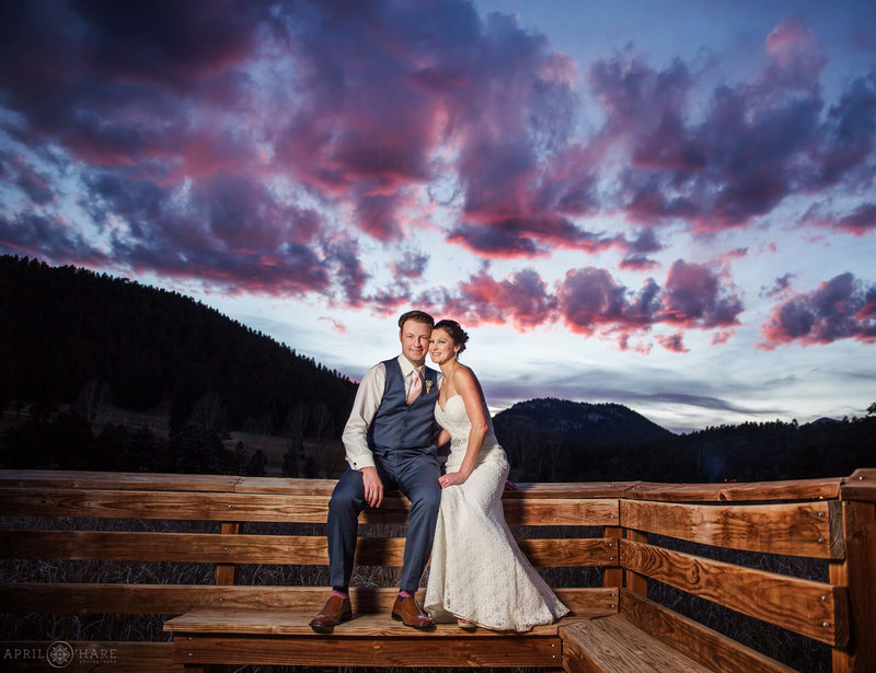 Dramatic Purple and Pink sunset backdrop for a couple posing on the Evergreen Lake House Boardwalk in Colorado