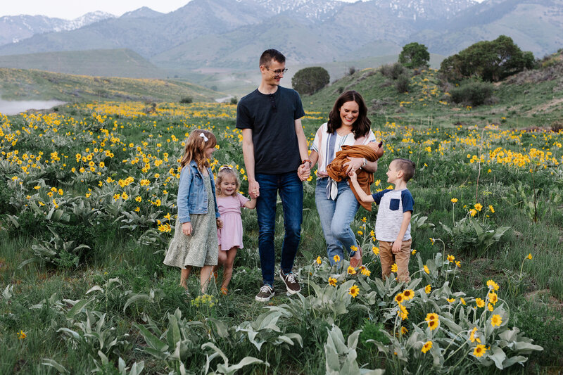 family photo of couple with 4 kids in a field of flowers