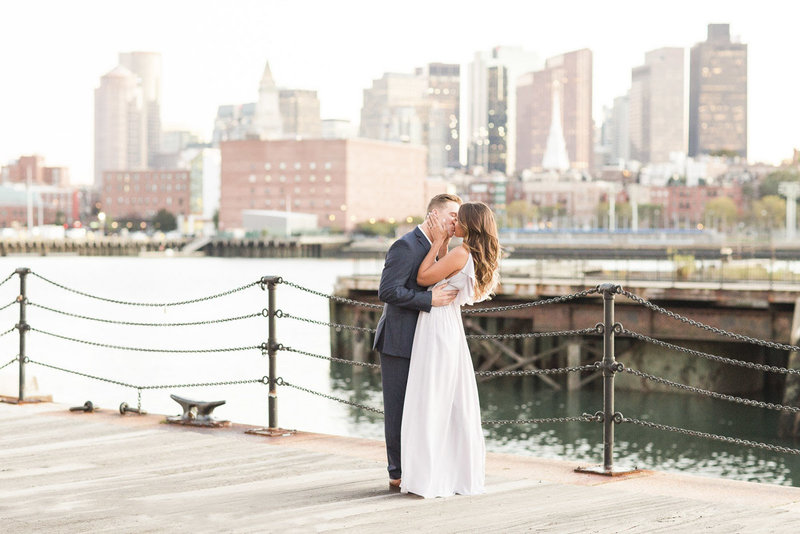 Couple kissing in front of Boston skyline
