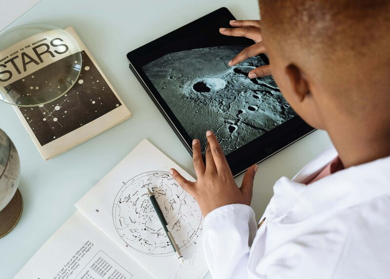 a young male student is on his ipad, learning about space
