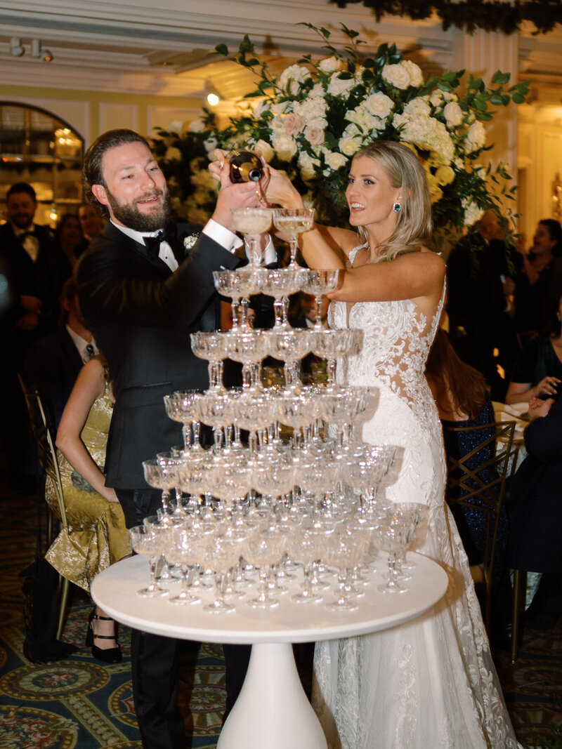 bride and groom filling a champagne tower at the virginia wedding reception
