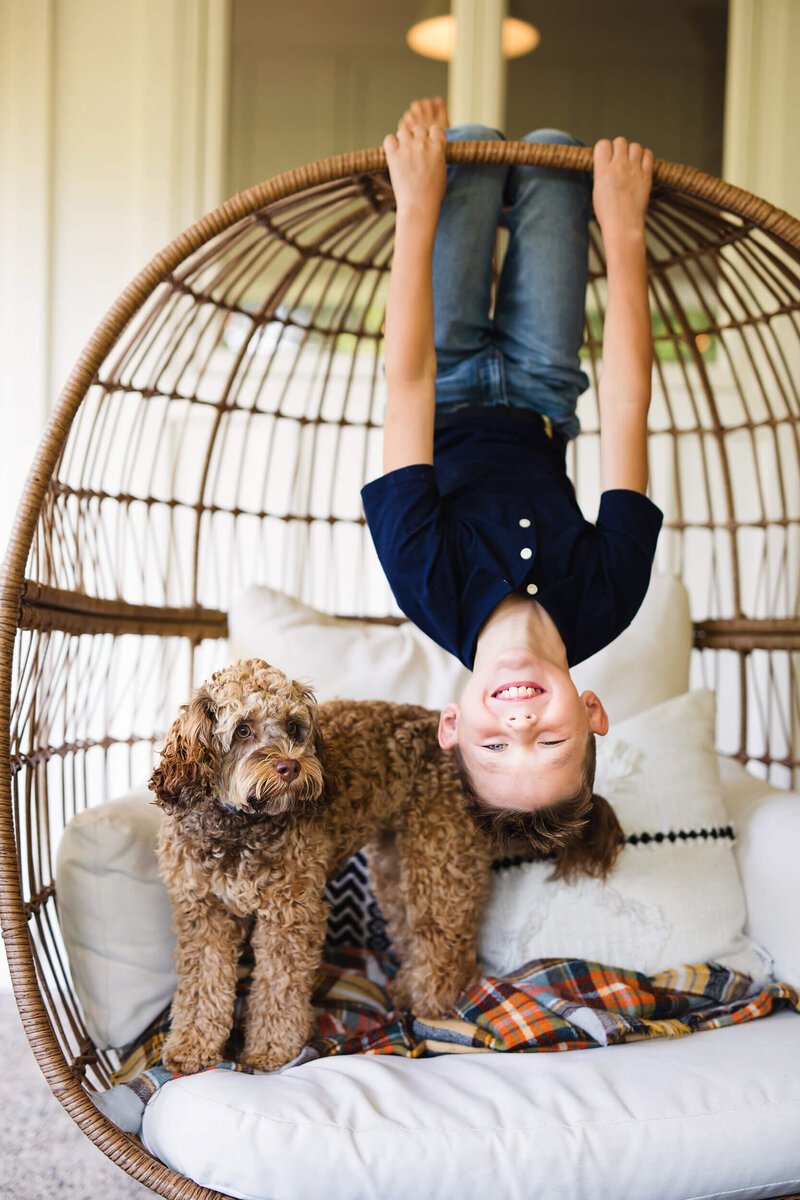 Boy hangs upside down with dog in Minneapolis for Family photos