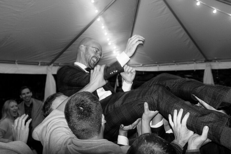 Groom being lifted up at wedding