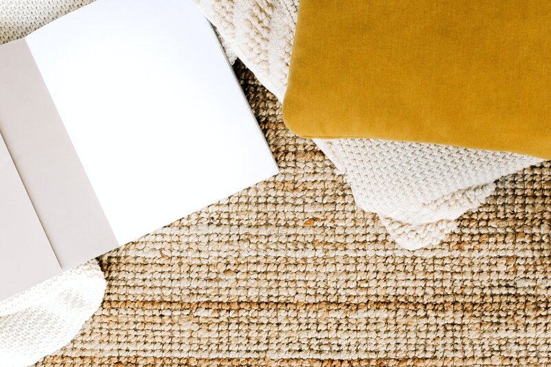 Yellow and white pillows on a tan rug