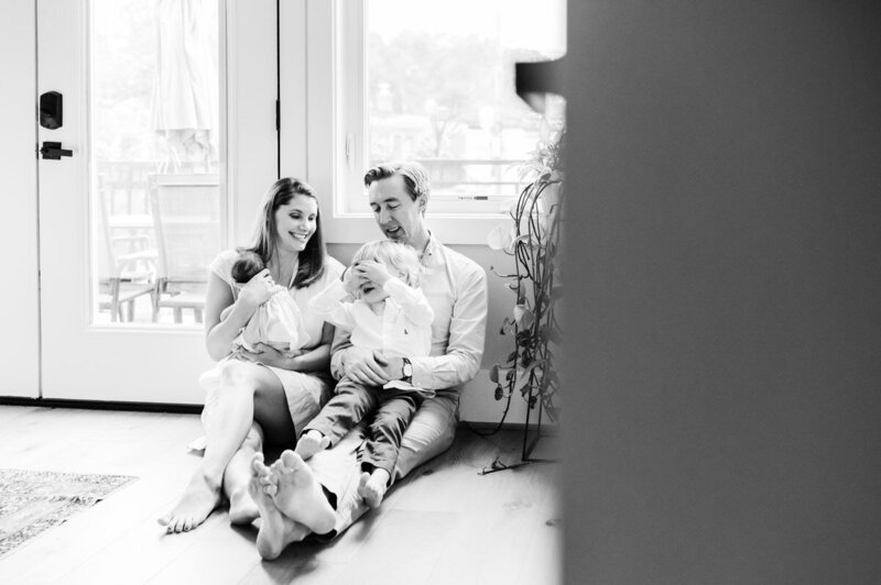 black and white photos of a family sitting on the floor by glass doors