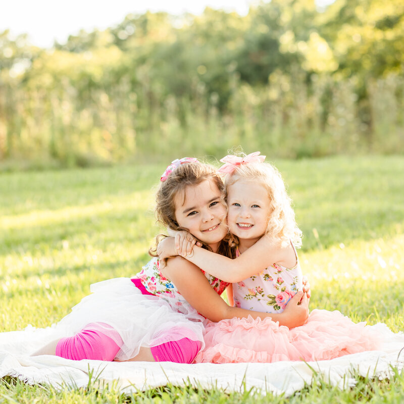 Sisters hugging in outdoor family session