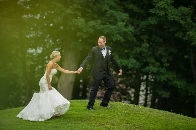 Groom leading bride off golf course at Lakeshore Country Club in Erie PA.