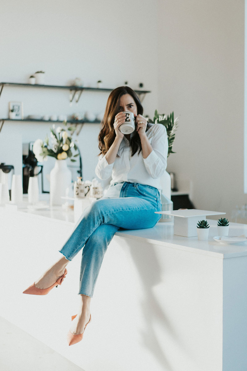 Idit Sharoni drinking coffee in her kitchen as she sits on the counter. She is a couples therapist in Florida. She is also a marriage counselor and online therapist. Learn more from this Florida therapist today.