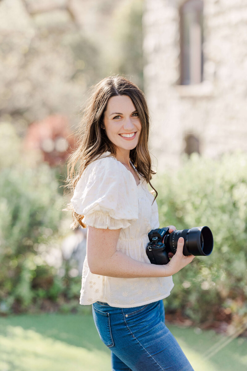 Los Angeles wedding photographer Rachel Paige Photography standing and smiling while holding camera in hand