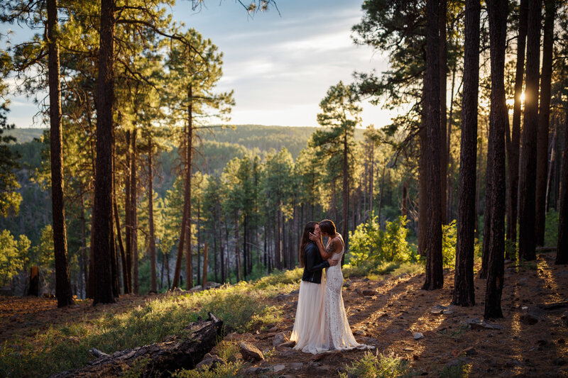 moody woodsy elopement in the forrest with two brides kissing