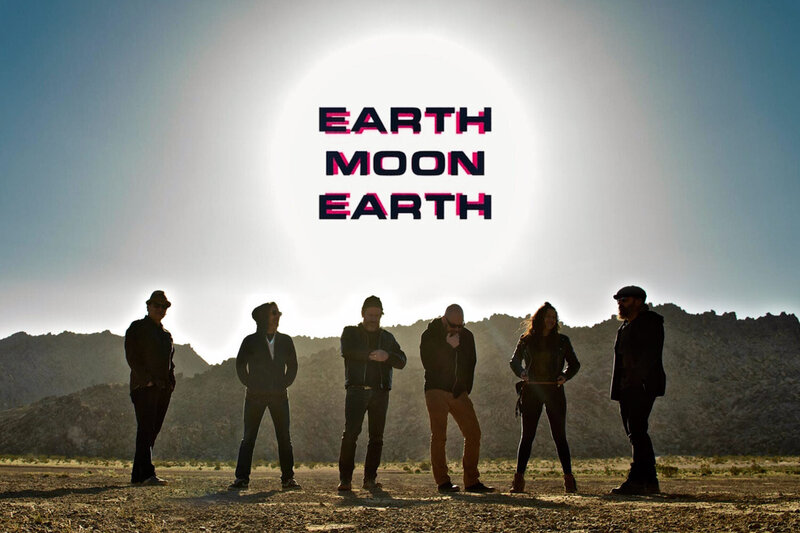 Band photo Earth Moon Earth six members in straight line against desert mountains logo in sun in sky above them