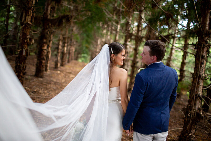Wedding Couple poses at  the woods with flying veil