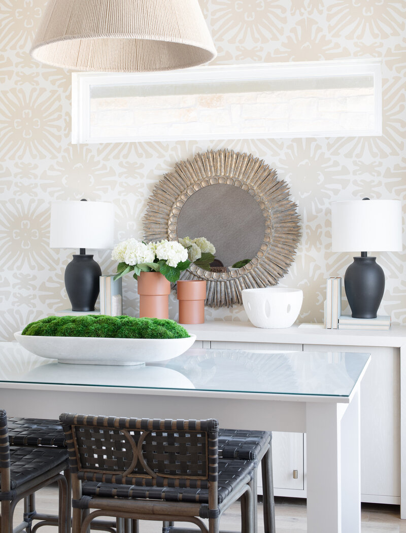 Bright dining room with wallpaper, sunburst mirror and mossy table decor