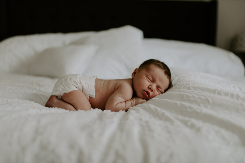 Sleeping newborn posed on a bed