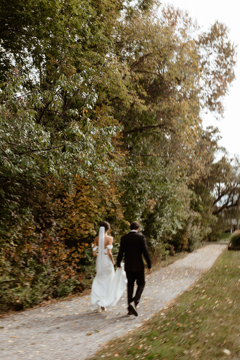 A couple walks together down a path after getting married in Virginia.