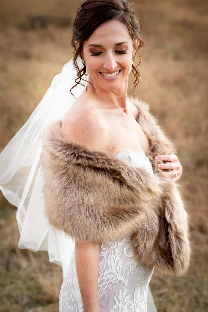 Bride showing collar bone while wearing her faux fur bridal wrap