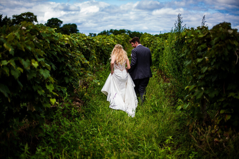 Couple walks through the vineyard at Quincy Cellars before their wedding