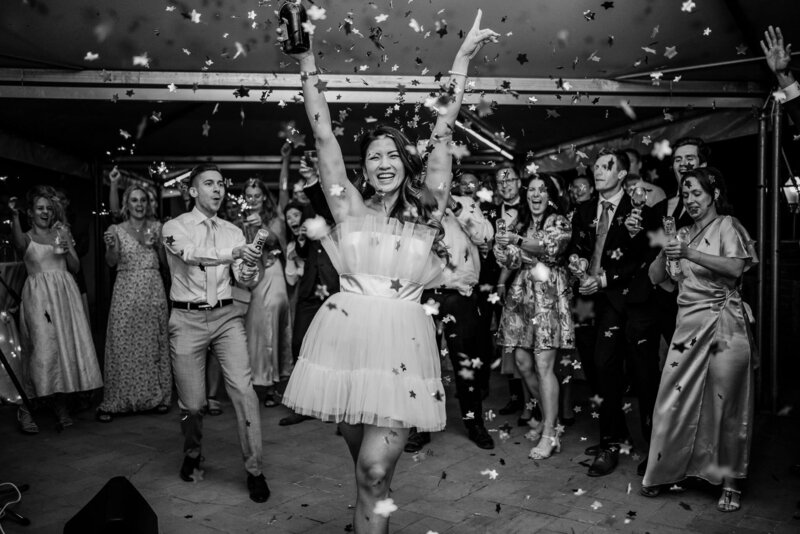 Confetti on the bride, wearing a short tulle dress