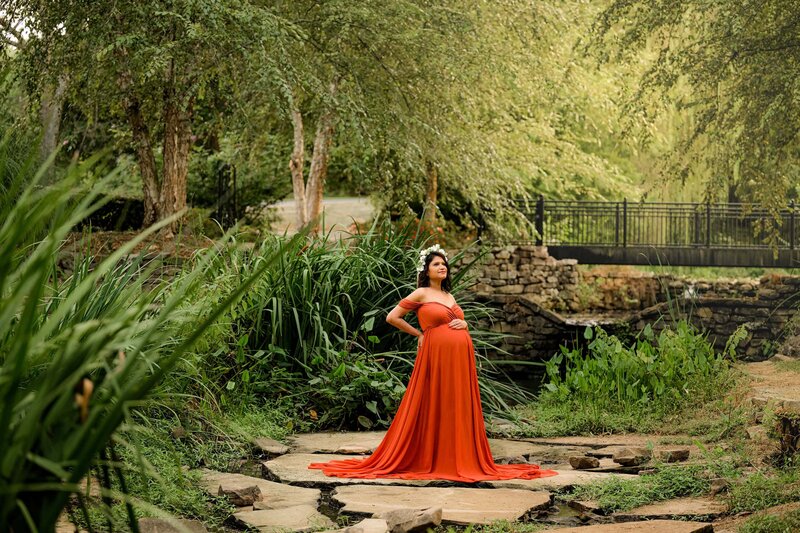 rust dress stands out  in charlotte garden  wearing floral crown during her maternity photos