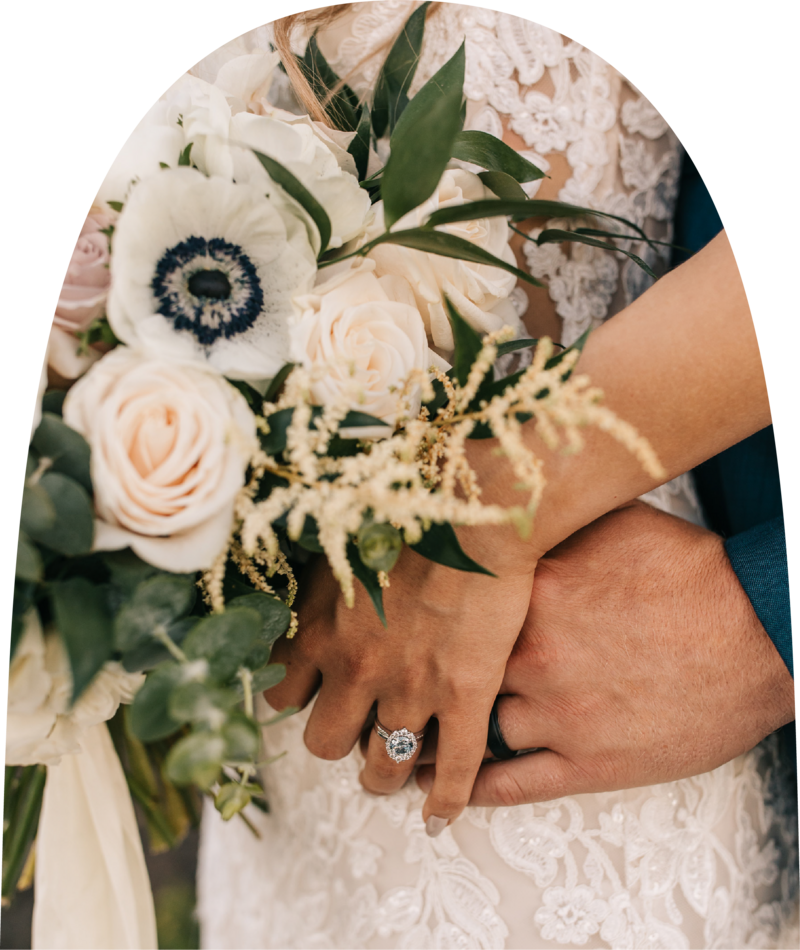 Bride and groom holding hands featuring bride's ring