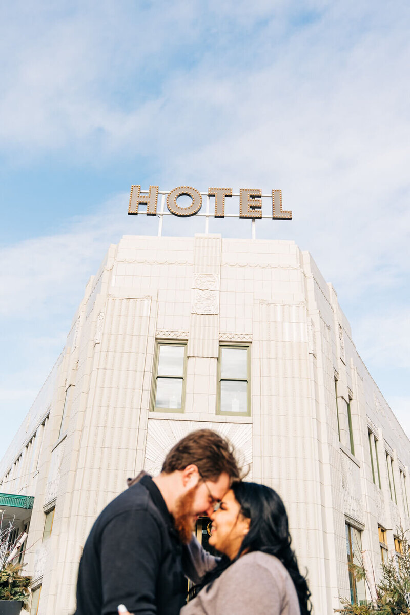 A couple embrace during their engagement session at the Bottleworks Hotel in downtown Indianapolis, Indiana.
