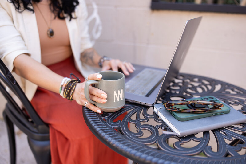 A-small-business-owner-poses-with-her-journal-laptop-and-coffee-during-detailed-shots-for-her-baltimore-brand-photos