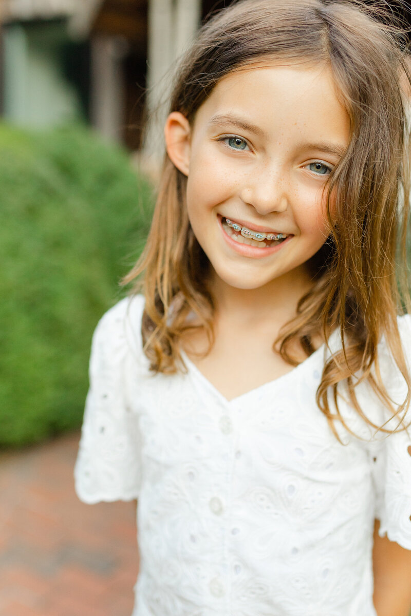 A girl with braces smiles big during her in-home family photo session in Lexington KY.