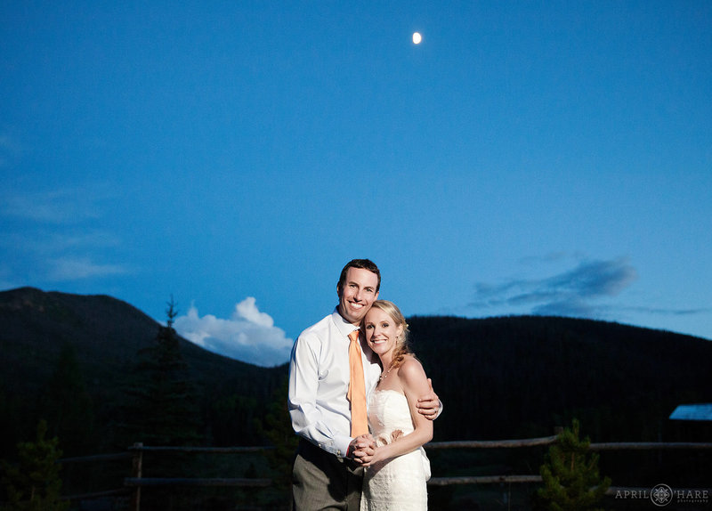 Wedding portrait at dusk with moon overhead at Snow Mountain Ranch