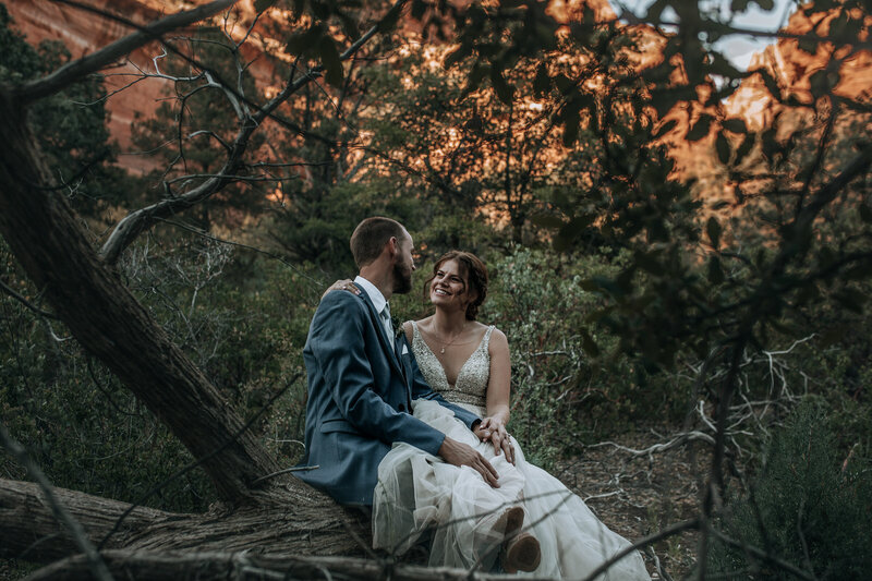bride and groom sitting in canyon in sedona arizona