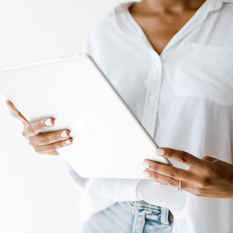 woman working on computer tablet with white shirt and jeans