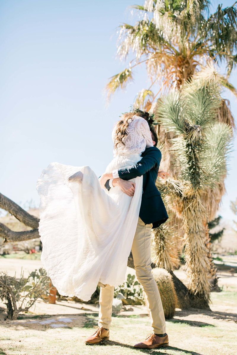 the groom lifts the bride off her feet during their elopement first look