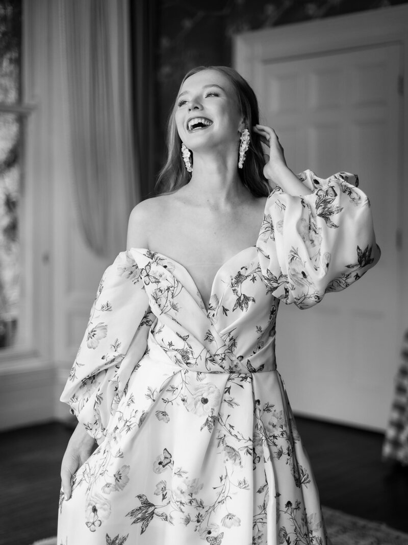 A-woman-in-a-floral-dress-joyfully-laughing