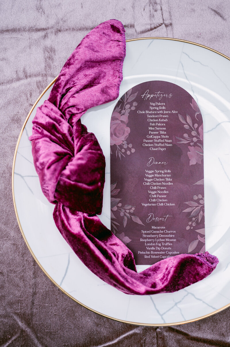 white and gold plate with purple handkerchief and purple menu