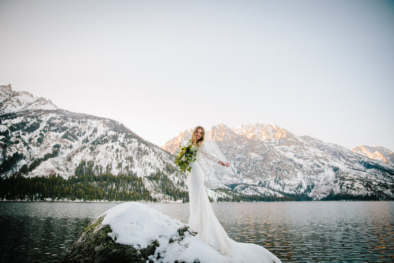 Jackson Hole photographers capture bride standing on rock after Grand Teton wedding