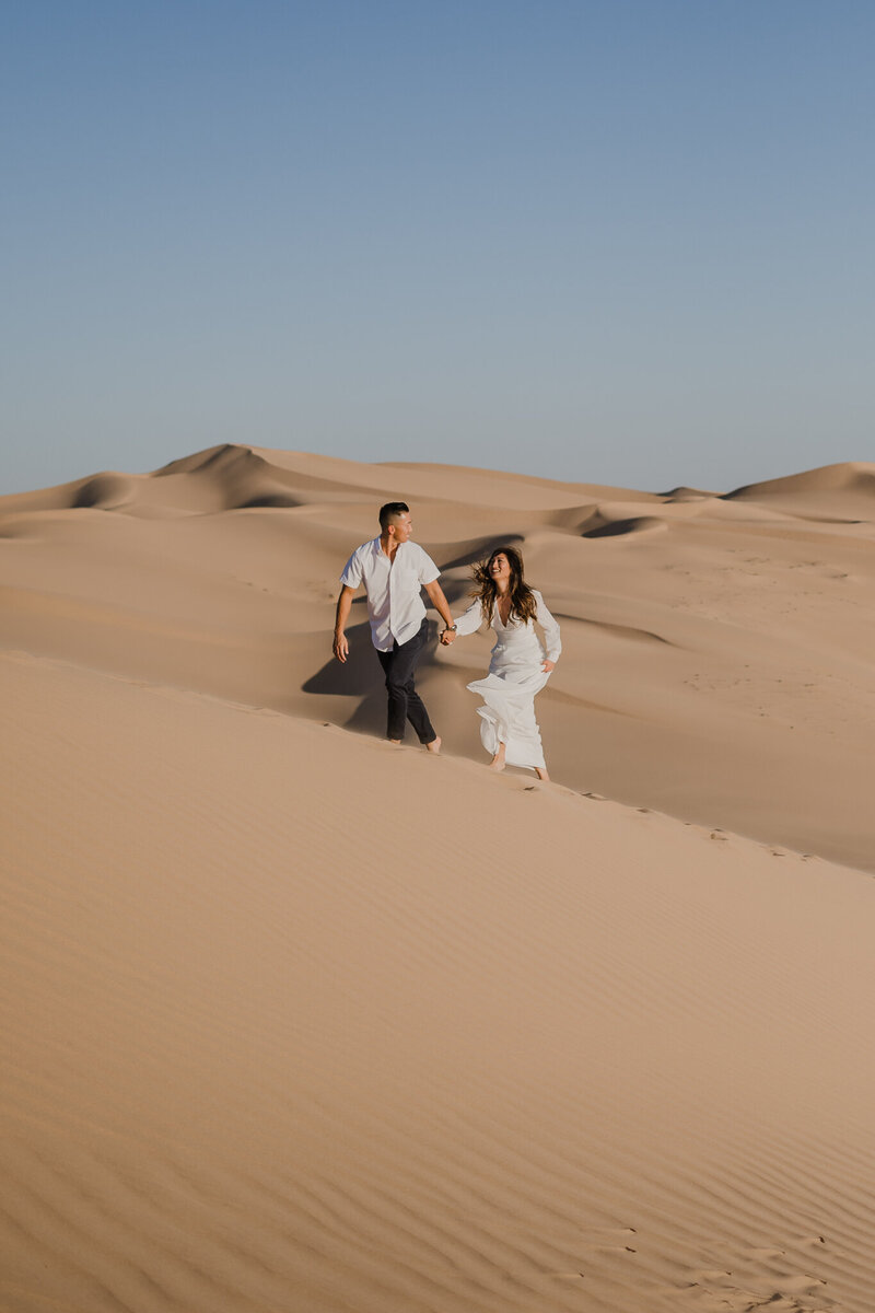 a cute couple that took their engagement photos in glalmis sand dunes california with an elopement photographer