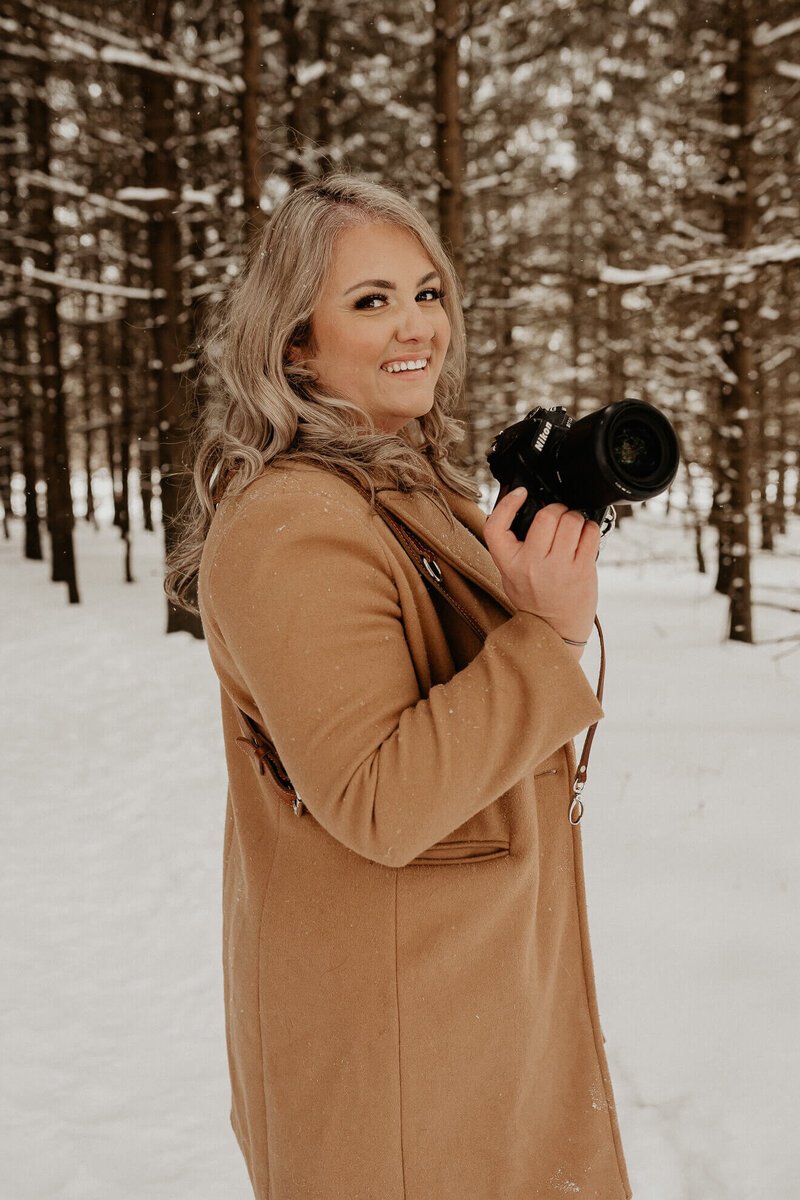 Photographer standing in snow with her Nikon camera