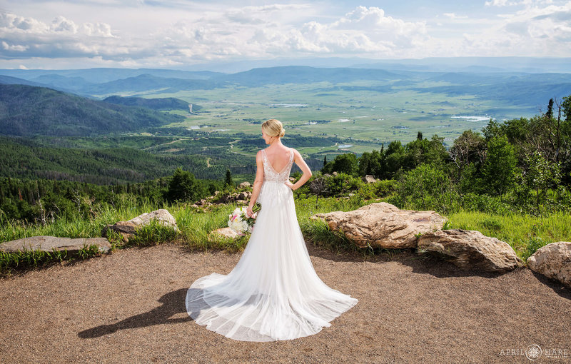 Bride shows off her dress on a super bright sunny day at Vista Overlook in Steamboat Springs