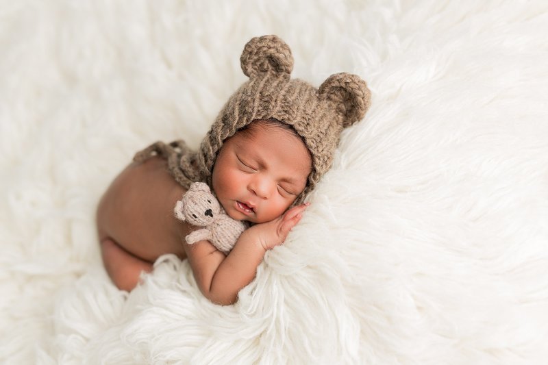 baby with stuffed bear and bear hat