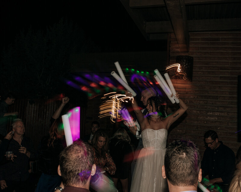 bride dancing with glow sticks at wedding reception